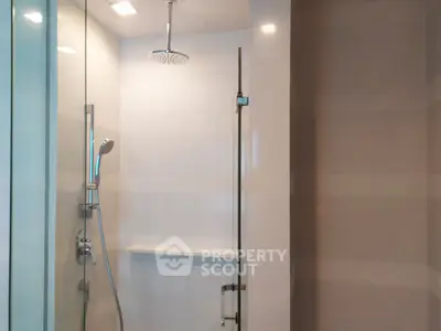 Modern bathroom with glass shower enclosure and sleek fixtures