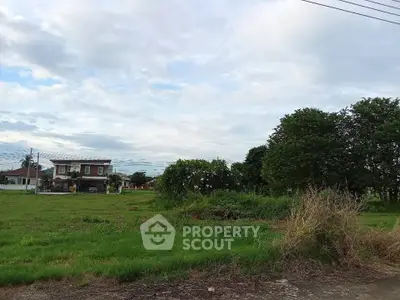 Spacious green land with a distant view of a house, perfect for development opportunities.