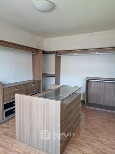 Spacious walk-in closet with wooden cabinetry and ample storage space.