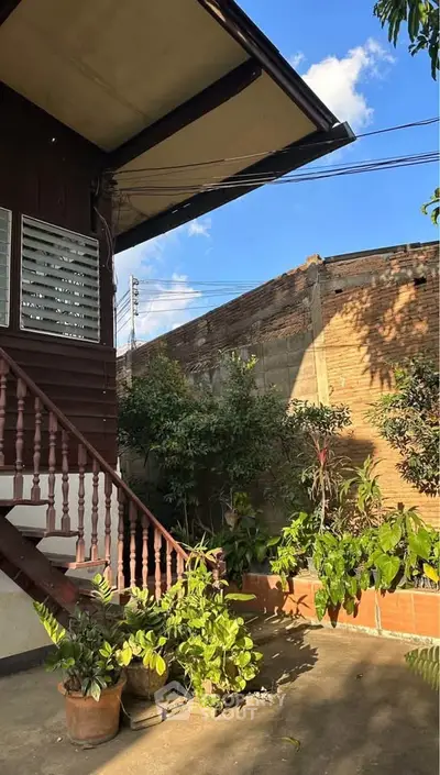 Charming outdoor garden space with lush greenery and rustic wooden staircase.