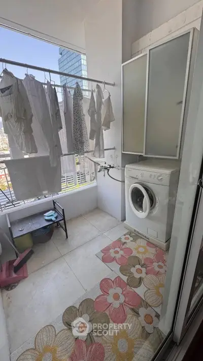 Charming balcony laundry area with washing machine and city view, perfect for urban living convenience.