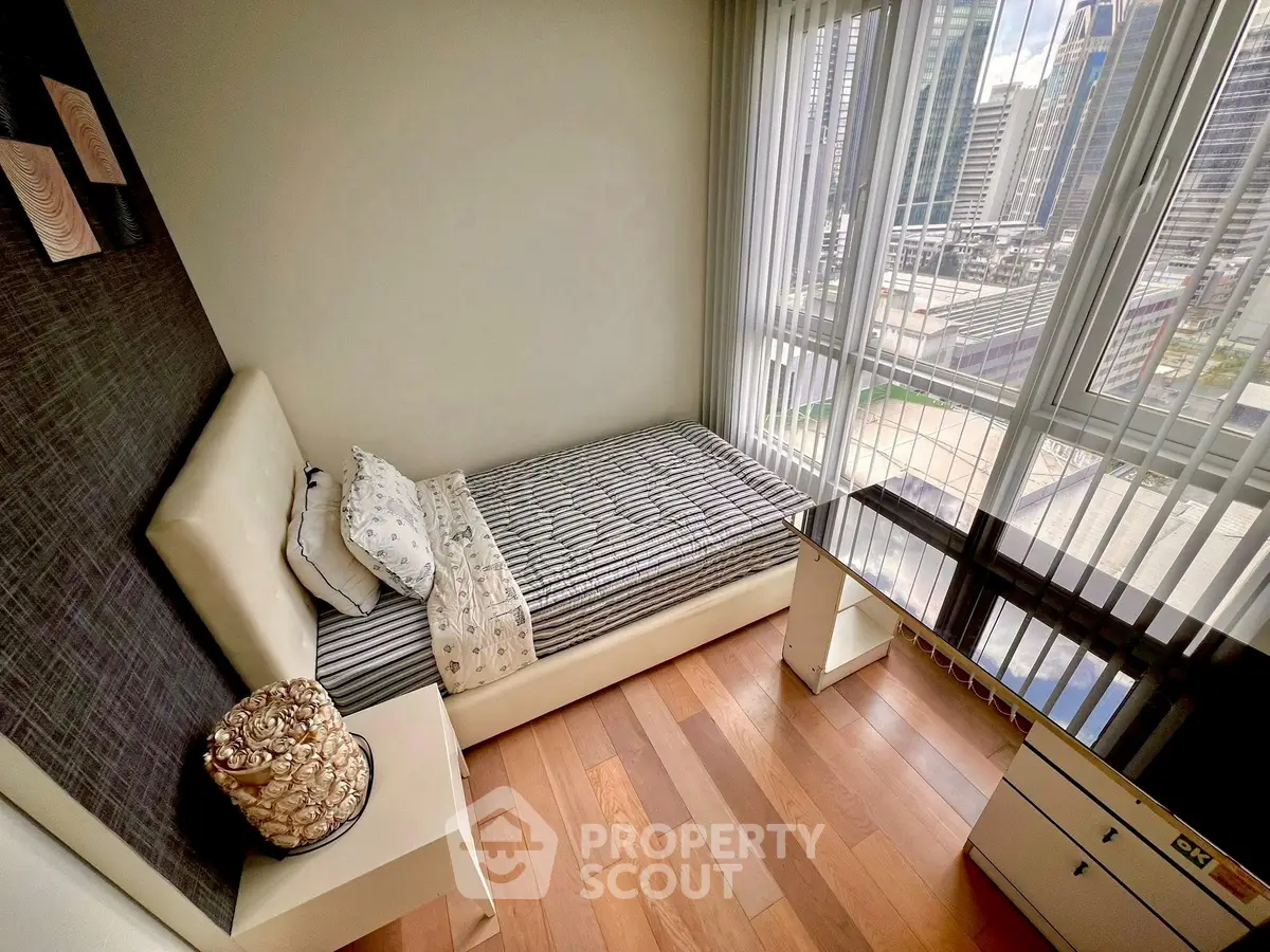 Cozy bedroom with city view, modern furnishings, and natural light