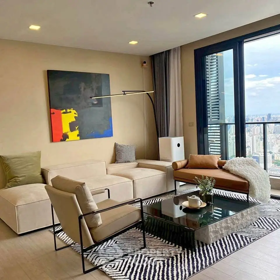 Modern living room with stylish furniture and city view, featuring a chic coffee table and abstract art.