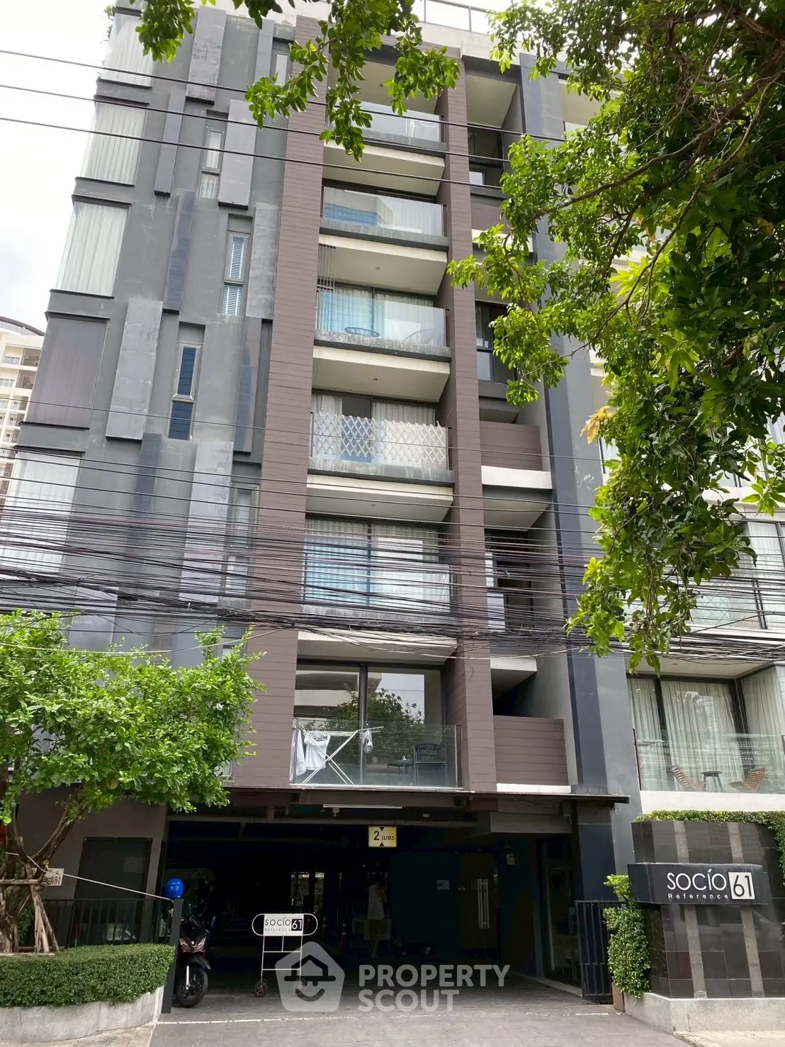 Modern urban apartment building with stylish facade and lush greenery, ideal for city living.