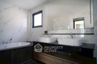Luxurious modern bathroom with dual sinks and elegant marble finishes.