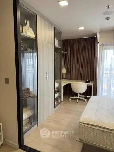 Modern bedroom with built-in wardrobe and study area, featuring sleek design and natural light.