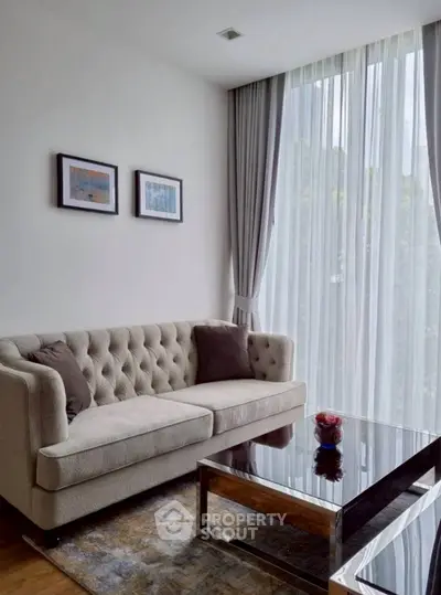 Elegant living room with plush sofa, large window, and modern decor