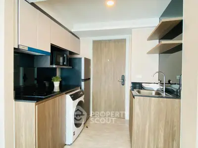 Modern kitchen with sleek appliances and stylish cabinetry in a compact layout.