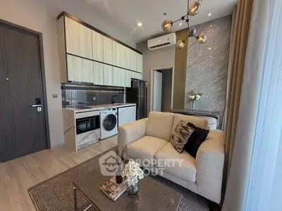 Modern living room with open kitchen, featuring sleek appliances and stylish decor in a cozy apartment.