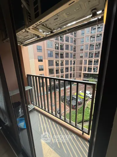 Modern apartment balcony with city view and parking area below