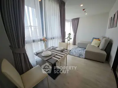 Modern living room with dining area, large windows, and stylish decor