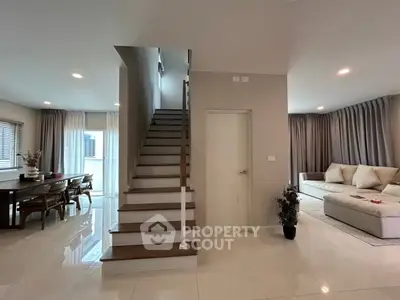 Modern open-plan living room with elegant staircase and dining area