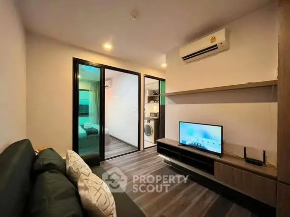 Modern living room with sleek design, featuring a wall-mounted TV and air conditioning, perfect for urban living.