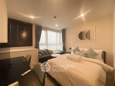 Modern bedroom with stylish decor and large window offering natural light