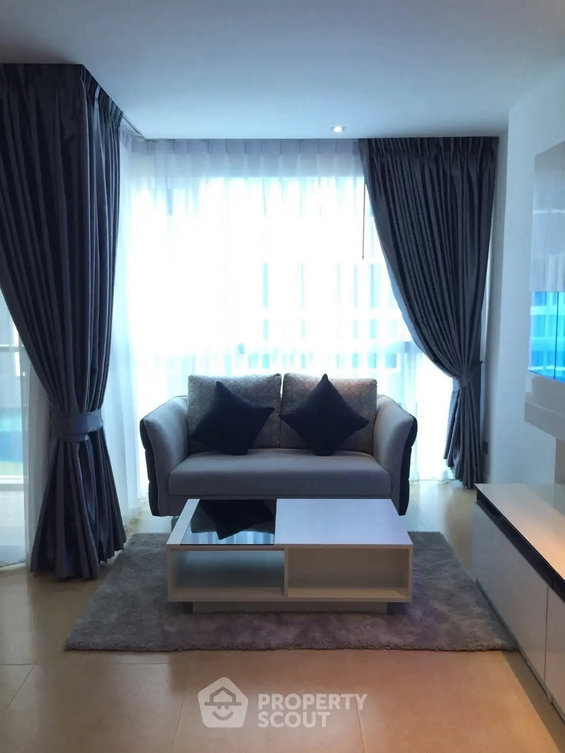 Stylish living room with modern sofa and elegant curtains, perfect for relaxation.