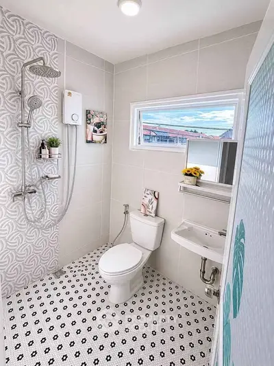 Modern bathroom with stylish tiles and natural light, featuring a shower and toilet.