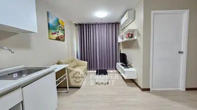 Modern living room with kitchenette, cozy sofa, and wall-mounted TV in a stylish apartment.