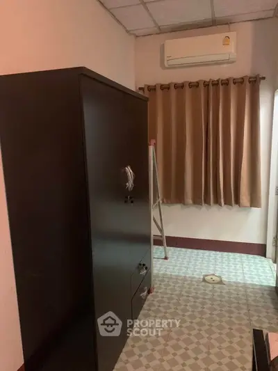 Cozy room with air conditioning and wardrobe, featuring tiled flooring and neutral curtains.