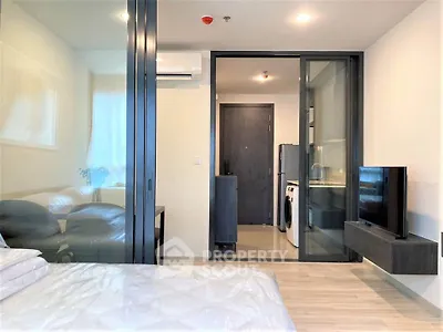 Modern bedroom with glass partition, sleek furniture, and in-unit laundry facilities.