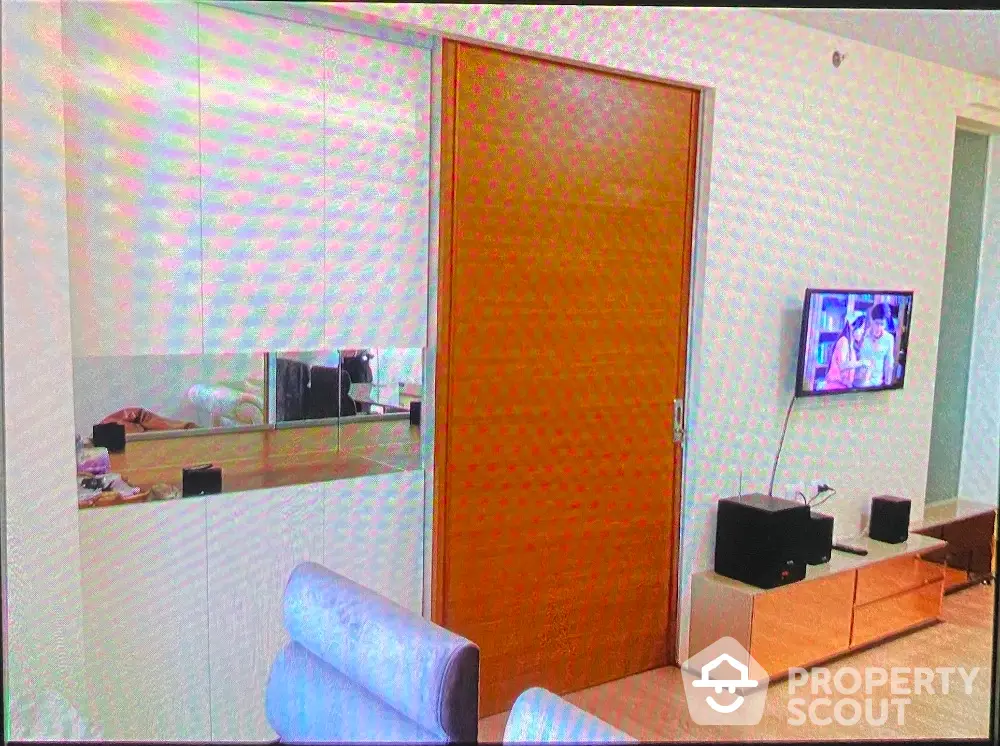 Modern living room with sleek wooden door and wall-mounted TV