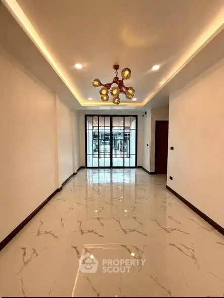 Spacious modern living room with elegant lighting and marble flooring, perfect for stylish urban living.
