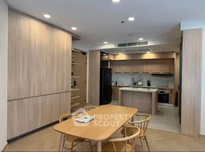 Modern kitchen with open layout and stylish dining area in contemporary apartment.