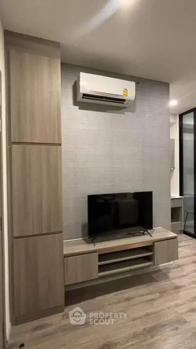 Modern living room with sleek TV unit and air conditioning in stylish apartment.