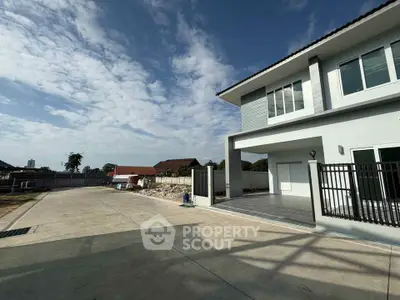 Modern two-story house with spacious driveway and clear blue sky.