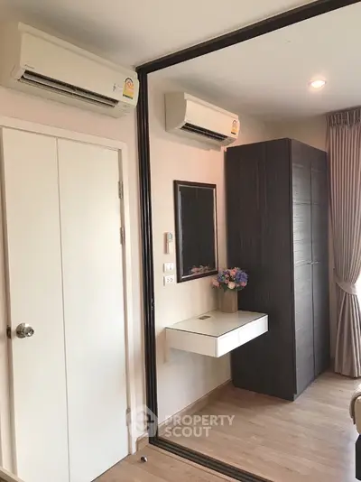 Modern bedroom with mirrored wardrobe and air conditioning