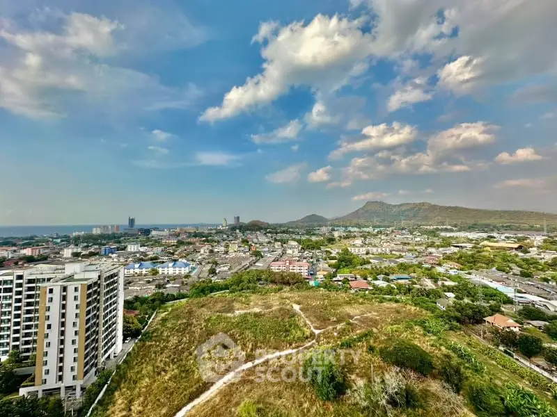 Stunning panoramic cityscape view with mountains and ocean in the background.