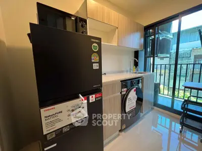 Modern kitchen with sleek appliances and balcony view in a stylish apartment.