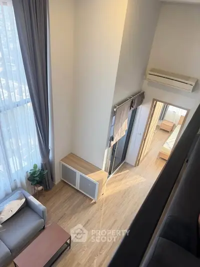 Modern loft apartment with high ceilings, large windows, and stylish furnishings.
