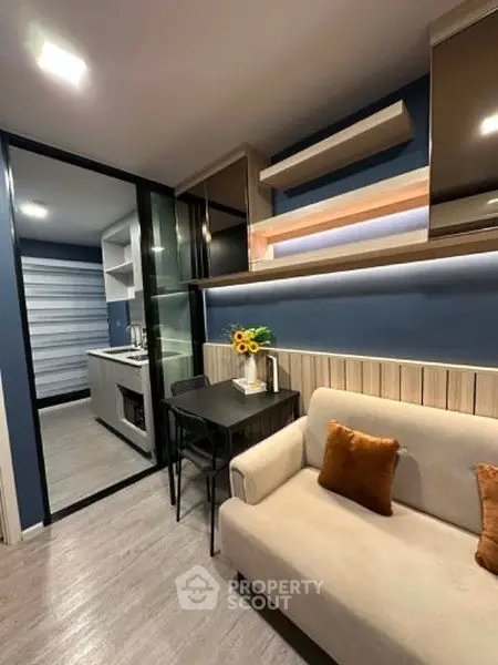 Modern living room with cozy sofa and stylish kitchen in open layout apartment.