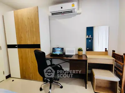 Modern study room with desk, chair, and wardrobe in a cozy apartment.