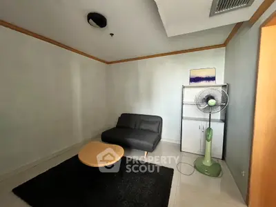 Cozy small living room with modern sofa and fan, perfect for relaxation.