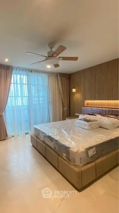 Luxurious bedroom with modern decor and large windows offering ample natural light.
