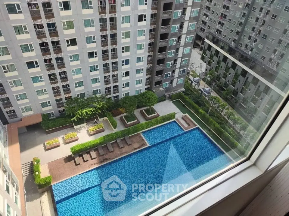Stunning aerial view of modern apartment complex with inviting swimming pool and lush greenery.
