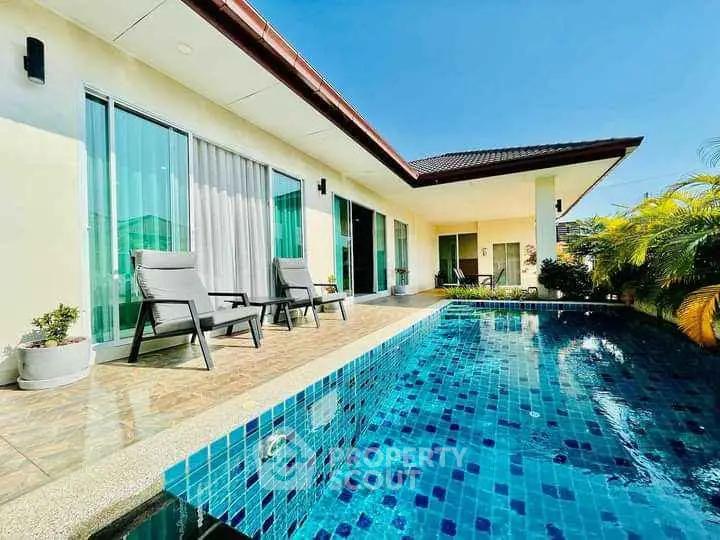 Luxurious villa with private pool and spacious patio under clear blue sky.