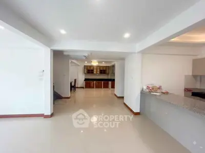 Spacious open-plan living area with modern kitchen and elegant lighting