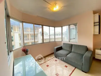 Bright living room with large windows and cozy sofa in modern apartment