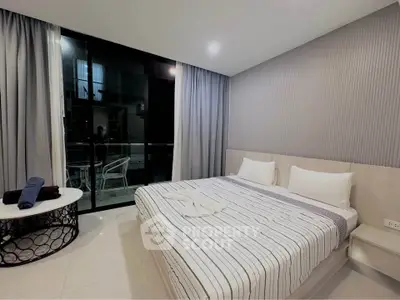 Modern bedroom with stylish decor and balcony access in a luxury apartment.