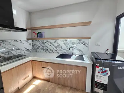 Modern kitchen with marble backsplash and sleek wooden cabinets