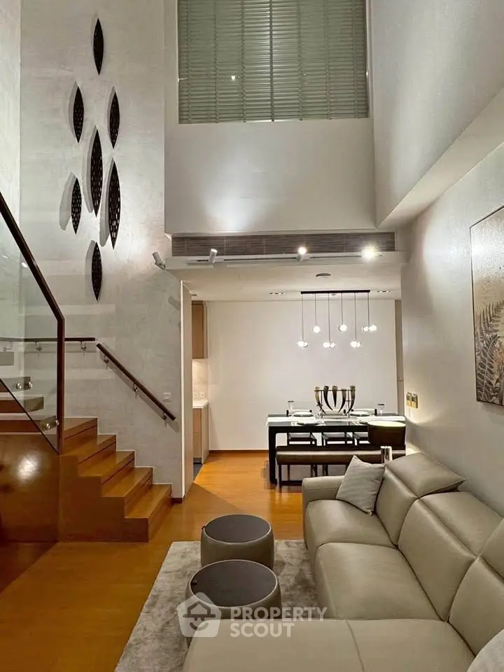 Luxurious modern living room with high ceiling and elegant staircase