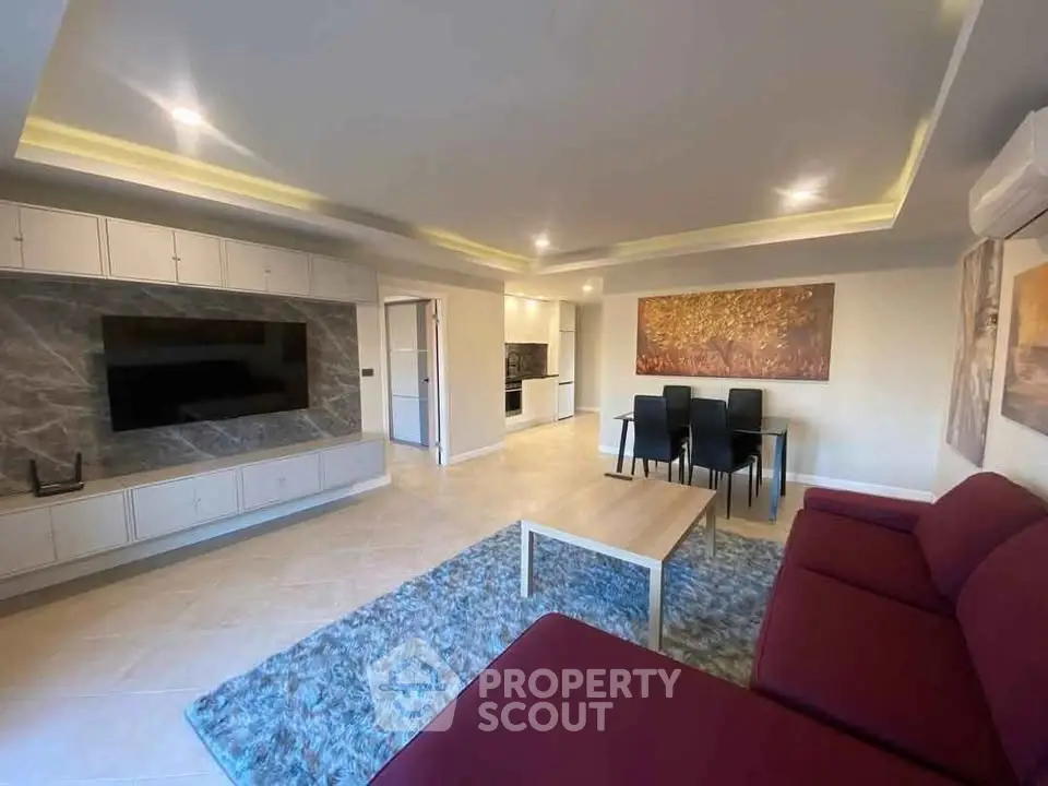 Spacious modern living room with elegant decor and open kitchen layout.
