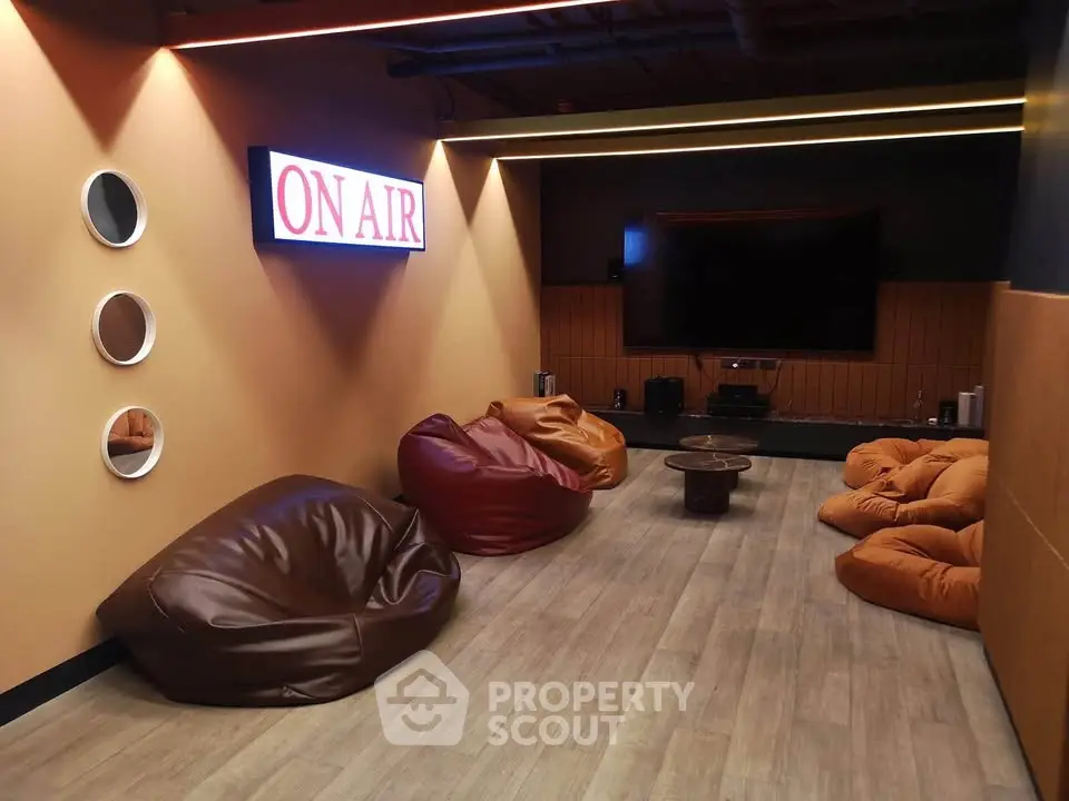 Modern media room with bean bags and large screen, perfect for entertainment and relaxation.