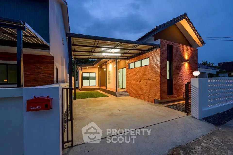Modern single-story house with brick facade and spacious driveway at dusk.