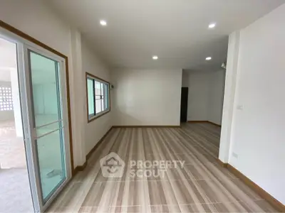 Spacious modern living room with wooden flooring and large windows