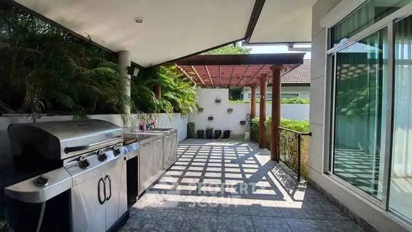 Spacious outdoor BBQ area with modern grill and lush greenery