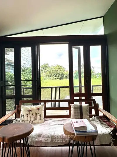 Charming living room with wooden furniture and scenic garden view.
