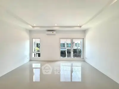 Spacious modern living room with large windows and sleek tile flooring